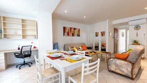 Un appartement moderne comprenant un coin repas, un salon et une cuisine.