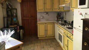A kitchen with yellow cabinets, a white microwave, a stove, and a sink. - 9-person country house with small spa (Capestang)