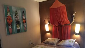 A bedroom with a canopy bed, two wall-mounted lights, a painting on the wall, and a power outlet. - 9-person country house with small spa (Capestang)
