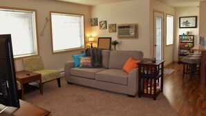 A living room with a sofa, armchair, and a television. - Downtown Charmer-2 bed/2 bath (Fargo)