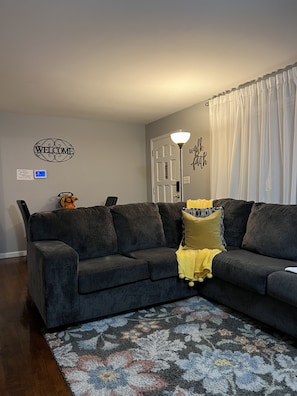 Cozy living space with a comfortable sofa, plush throw, and patterned rug.