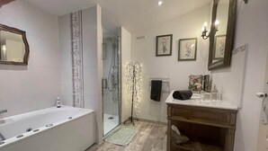 A modern bathroom with a bathtub, a glass shower enclosure, a vanity with a mirror, and a wooden shelf. - Almond room with whirlpool bath (Plan-de-la-Tour)