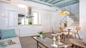 Una cocina moderna con armarios blancos, un microondas y una campana extractora de acero inoxidable.