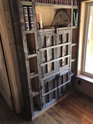 Una libreria in legno rustica con libri e oggetti decorativi.