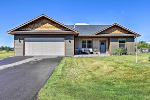A two-story house with a garage, a front porch, and a well-maintained lawn.