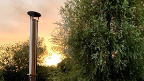 A hot tub with a metal heater and a wooden deck. - 16th century grade II* farmhouse with hot tub and wild swimming (Harleston)
