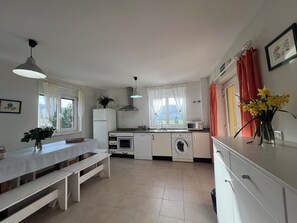 A compact kitchen with a dining area, a washing machine, and a microwave.