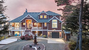 Une maison à deux étages avec un porche à l’avant, un garage et une allée.