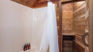 Un interior de madera con una bañera, un cortinón de ducha y una toalla.