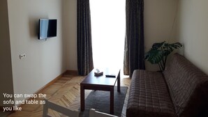 A living room with a sofa, table, and TV. - Cozy clean and bright studio8 (Arabkir)