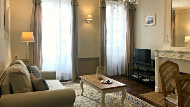 Un soggiorno con divano, tavolino, televisione e camino.