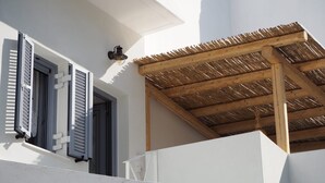 A building with white walls, wooden beams, and a thatched roof structure.
