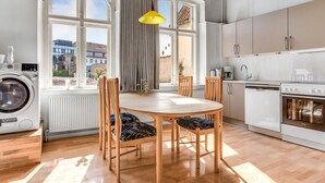 Una cocina con una mesa de comedor, sillas, lavadora y radiador.