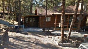 A log cabin with a front porch, surrounded by trees. - Cabin in the Pines, Prescott, AZ (Prescott)