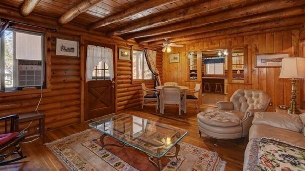 A log cabin interior with a dining area, a sofa, and a glass coffee table. - Cabin in the Pines, Prescott, AZ (Prescott)