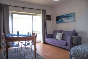 A room with a pool table, a purple sofa, and a painting on the wall. - Wonderful apartment right on the beach (Costa da Caparica)