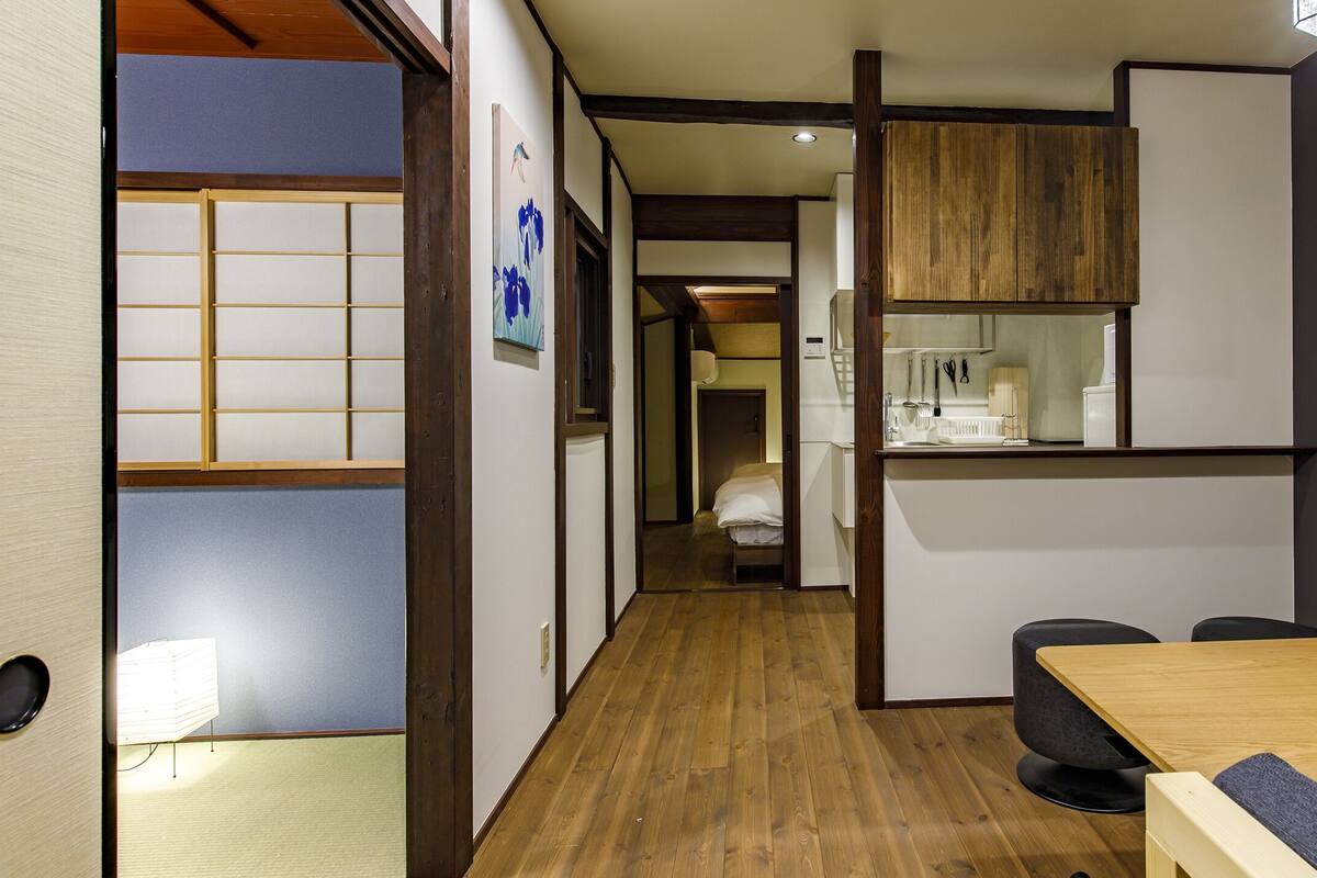 A traditional Japanese-style room with tatami flooring, a low wooden table, and a sliding door.