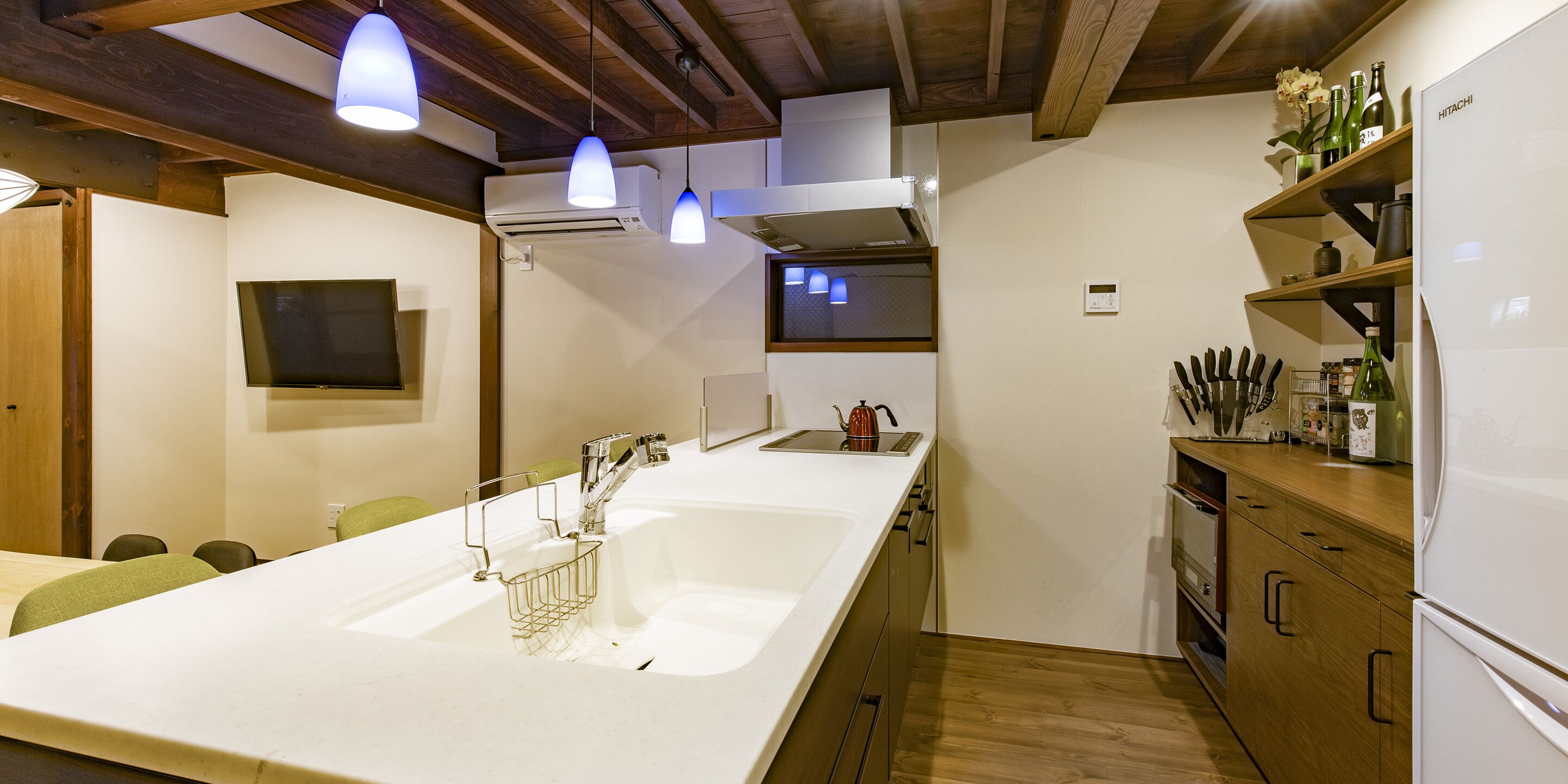 A modern kitchen with a large island, wooden cabinets, and a built-in oven.