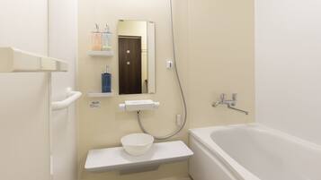 A bathroom with a bathtub, a sink with a soap dispenser, a mirror, and a showerhead.