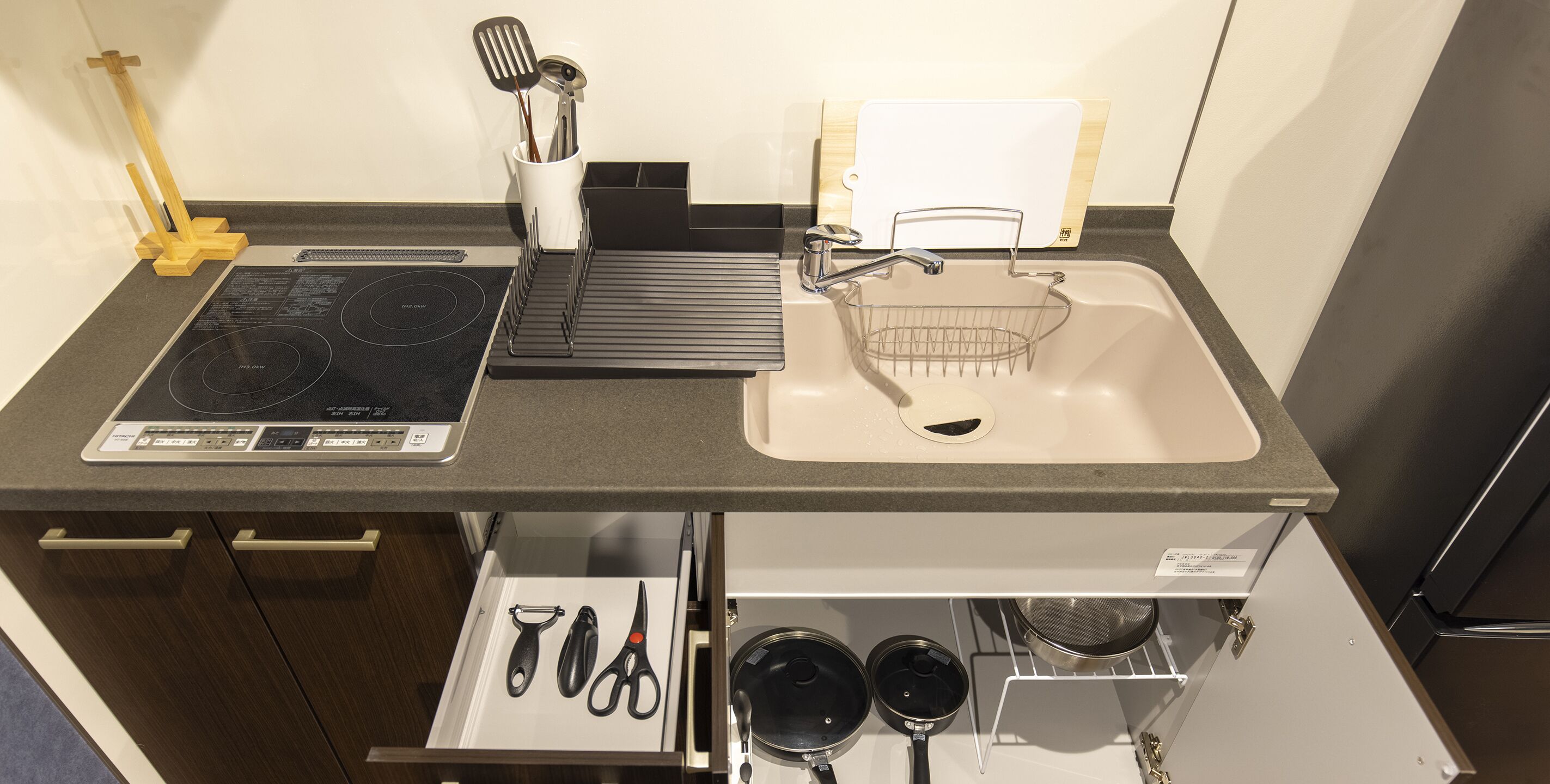 A kitchen with a built-in stove, sink, and storage drawers.