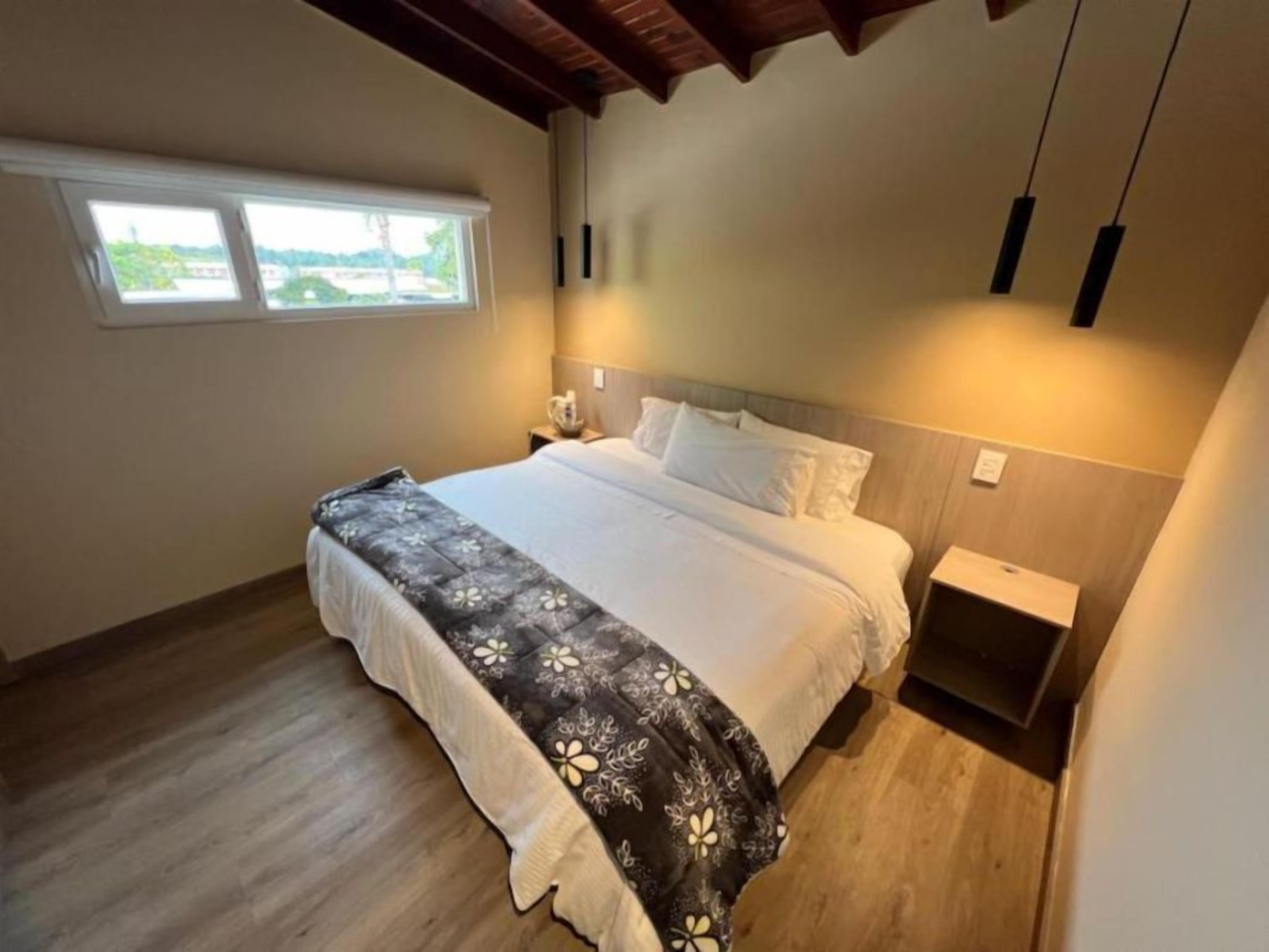 Una camera da letto con un letto, un comodino e una finestra.