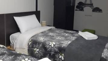 A bedroom with a bed, a wardrobe, and a wall decal of the Eiffel Tower.