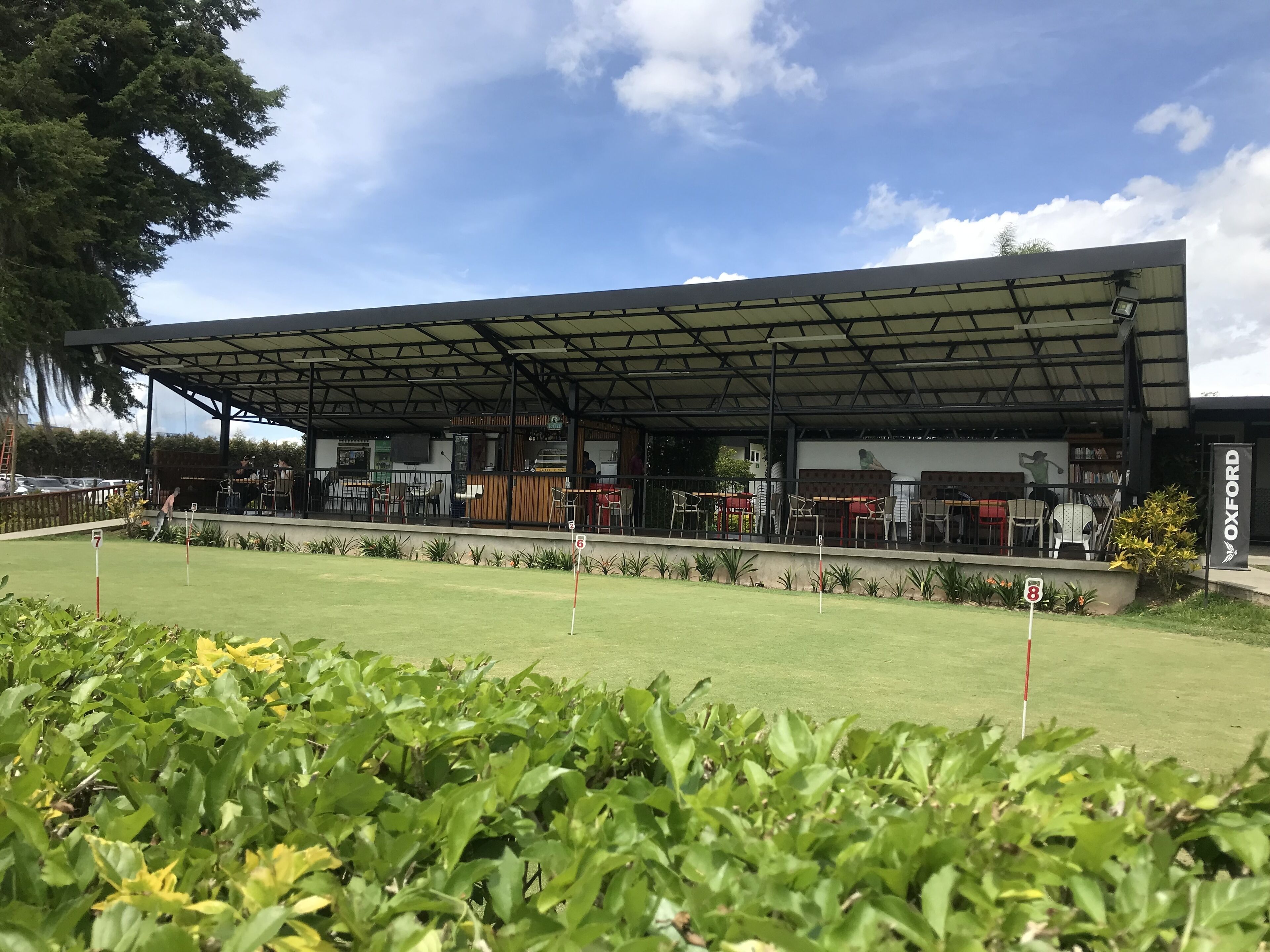 A golf course with a covered pavilion, a restaurant, and a flag indicating hole 8.