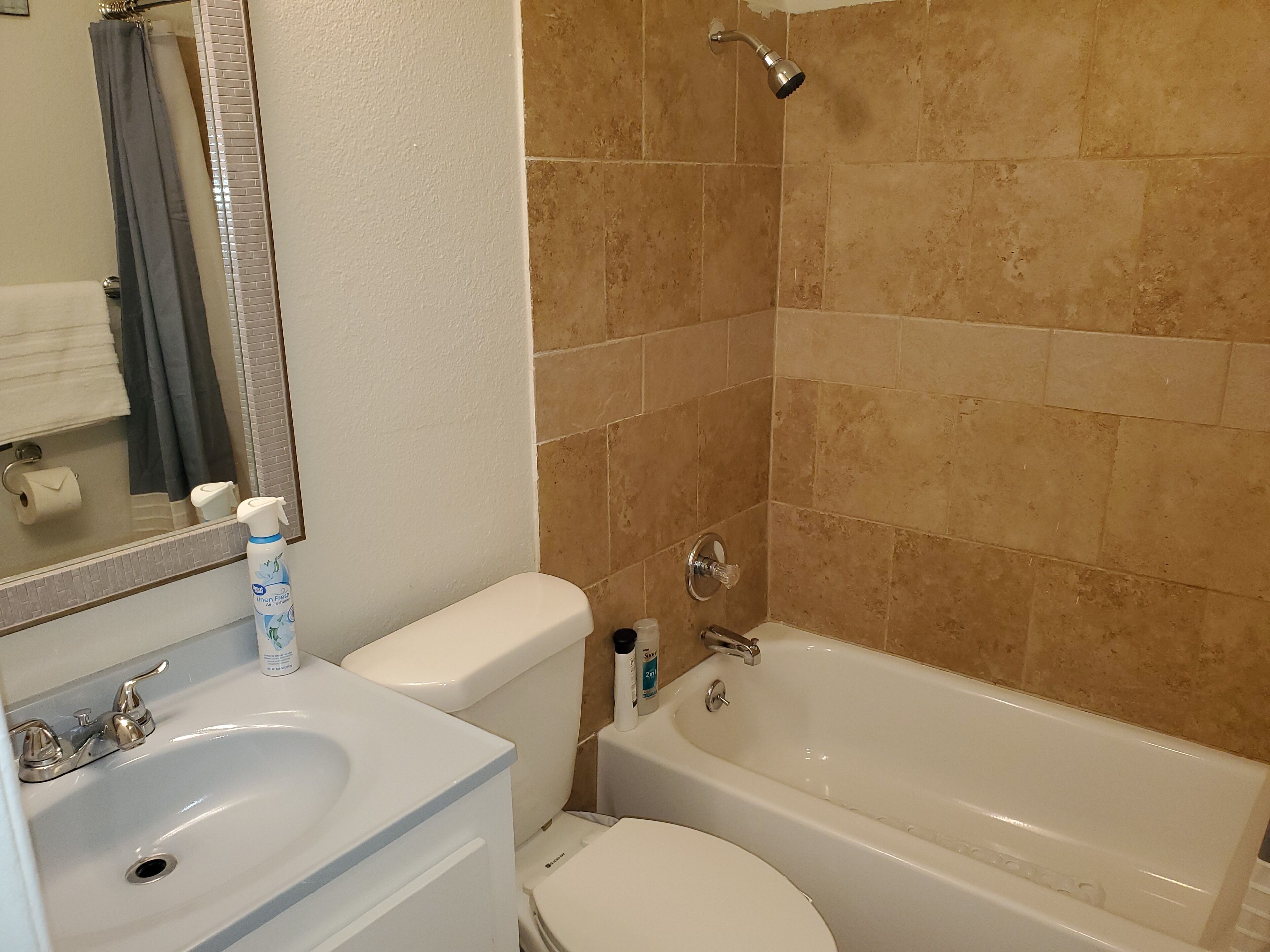 A bathroom with a white sink, toilet, and bathtub.