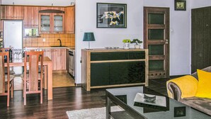 A compact living space with a dining area, kitchen, and a sofa with a cushion. - 1 bedroom cozy apartment in Ostroda (Ostroda)