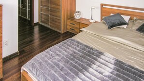 A bedroom with a bed, bedside table, lamp, and a wardrobe. - 1 bedroom cozy apartment in Ostroda (Ostroda)