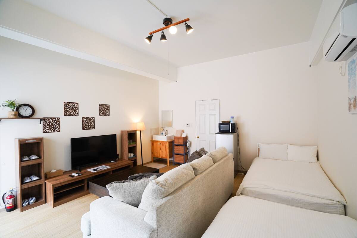 A modern living room with a sofa, TV, and entertainment unit.