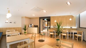 A modern cafe with wooden furniture, a coffee machine, and potted plants. - Brown Dot Hotel Jinju Chungmugong (Jinju)