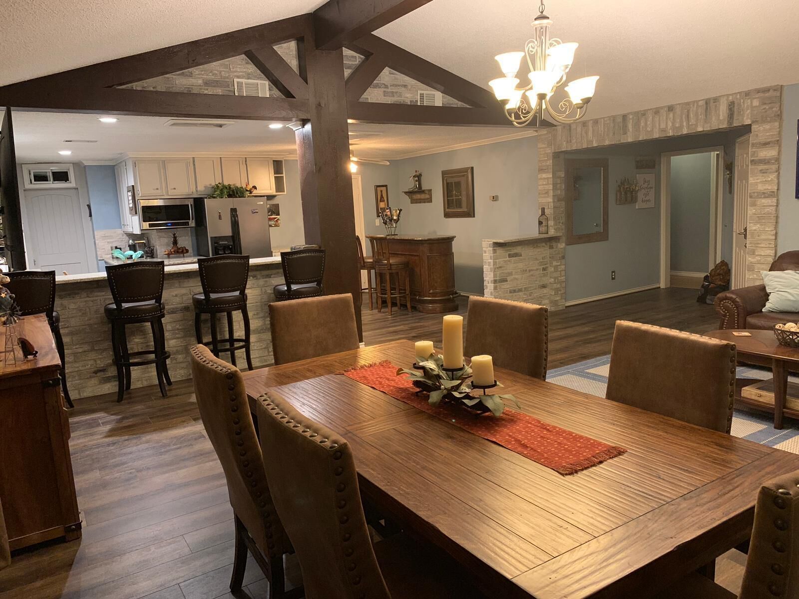 A dining area with a wooden table, six chairs, and a chandelier.
