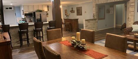 A dining area with a wooden table, six chairs, and a chandelier.