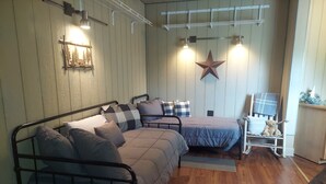 A cozy room with a bed, a rocking chair, and a small table.