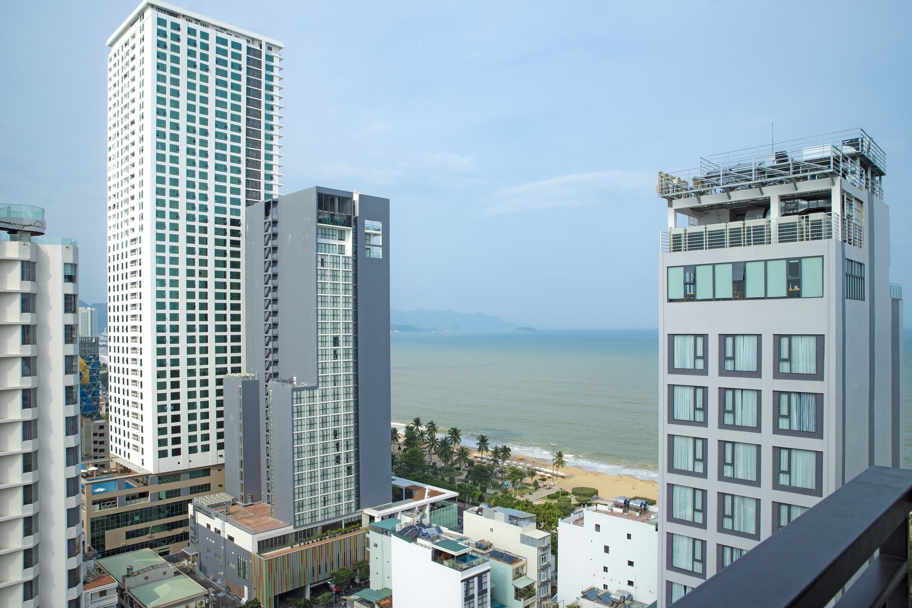 A high-rise hotel with a view of the beach and ocean.