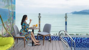 Een vrouw dineert aan een tafel met uitzicht op de oceaan.