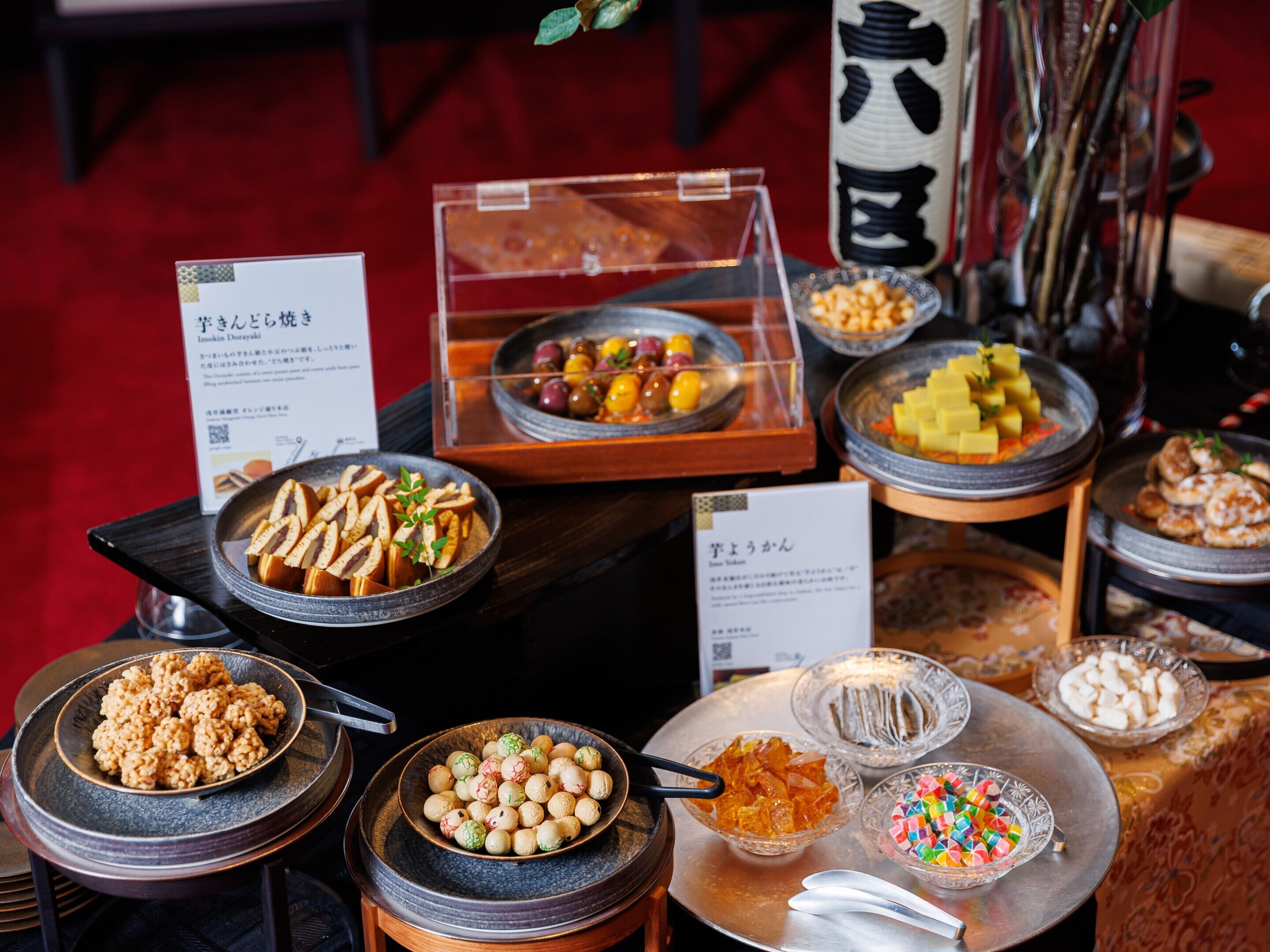 A buffet with various dishes including sushi, pickled vegetables, and sweets.