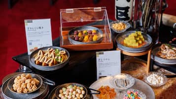 A buffet with various dishes including sushi, pickled vegetables, and sweets.