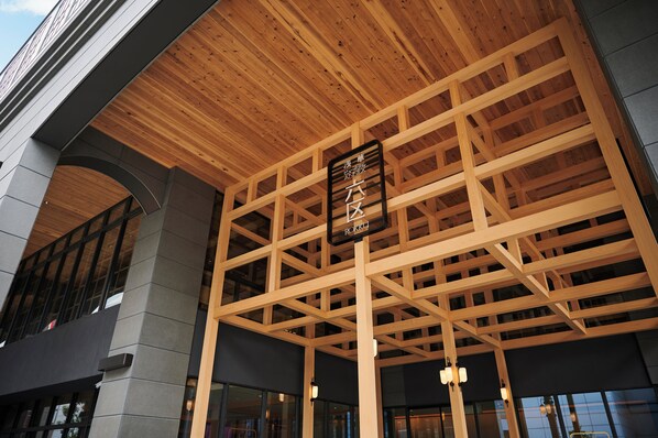 A building with a wooden ceiling structure, a sign with Japanese characters, and large windows. - Asakusa View Hotel Annex Rokku (Tokyo)