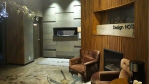 A modern hotel lobby with a wooden accent wall, a fireplace, and a seating area. - Lexy Hotel (Daejeon)