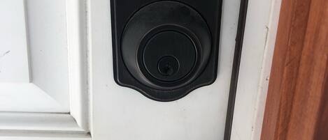 A door with a numeric keypad lock and a keyhole below it.