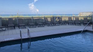 A pool area with lounge chairs and a view of the ocean. - Spacious 3 Bedroom, 2 1/2 bath Condo, Steps to the beach! 2 pools and Hot Tub! (Bradenton Beach)