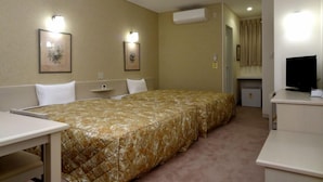 Une chambre d’hôtel équipée d’un lit « queen-size », d’un bureau, d’une chaise, d’une télévision et d’un appareil de climatisation.