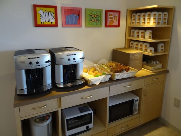 A kitchenette with two coffee makers, a microwave, a toaster, and a basket of bread and fruit. - Family Lodge Hatagoya Kitakyushuyahata (Kitakyushu)