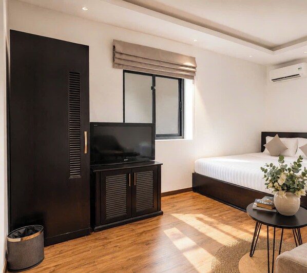 Una habitación de hotel moderna con cama, televisión, armario y ventana con vistas.
