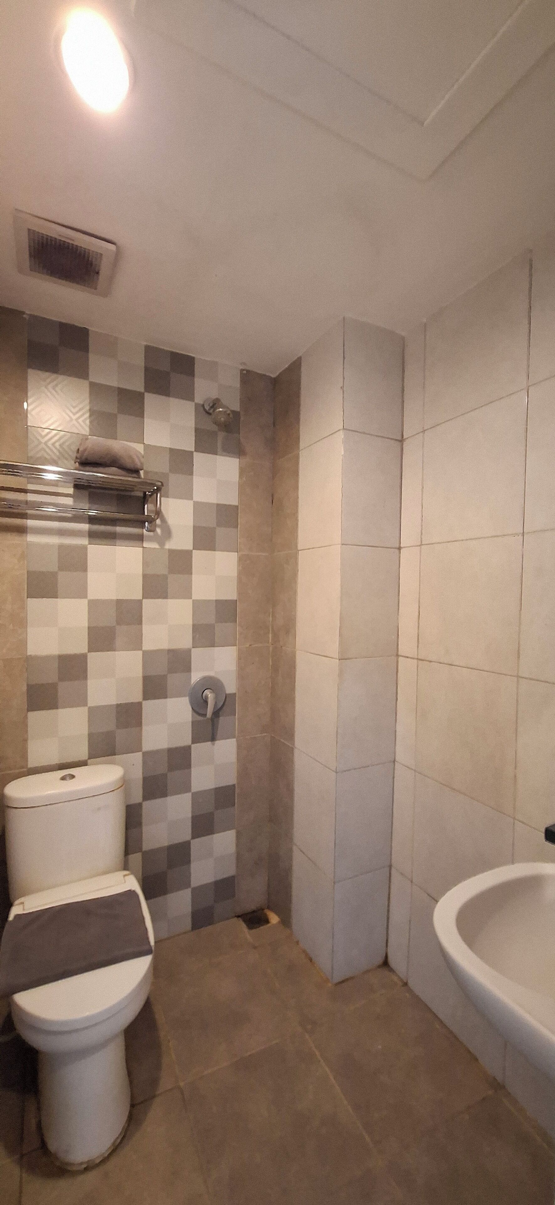 A bathroom with a toilet, a shower, and a sink.