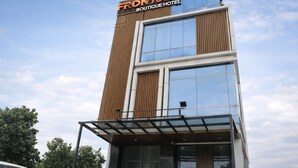 Un hôtel-boutique moderne, reconnaissable à son enseigne bien visible indiquant « FRONTONE BOUTIQUE HOTEL ».