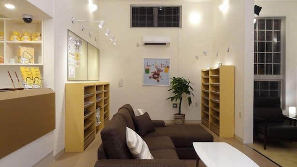 A cozy living area with a brown sofa, a white table, and yellow shelving units.