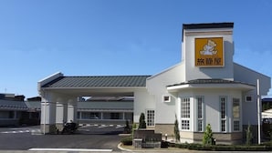 A building with a sign featuring a cartoon character and Japanese text, indicating it is a restaurant or cafe.